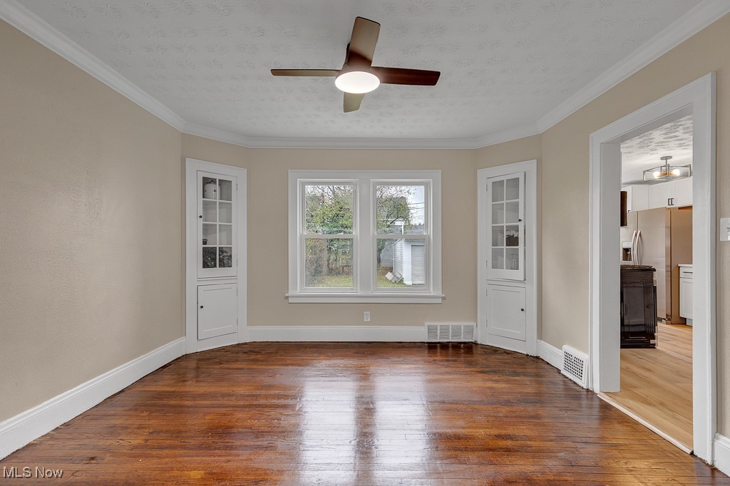 2127 Rossmoor Road Cleveland Heights, OH 44118 - Photo 8 of 21 Spare room with a ceiling fan, hardwood / wood-style flooring, and visible vents