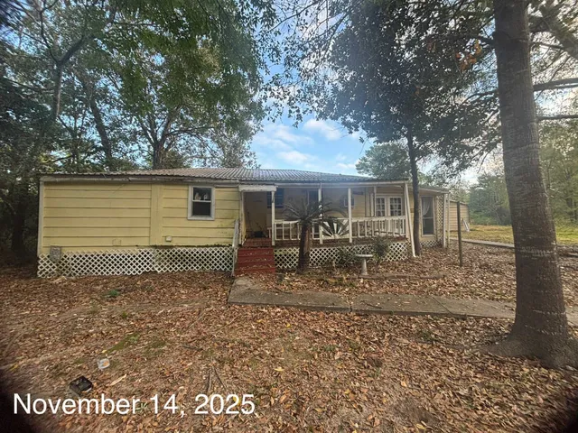 a backyard of a house with table and chairs