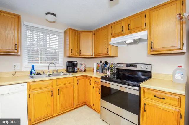 a kitchen with stainless steel appliances granite countertop a sink a stove and cabinets