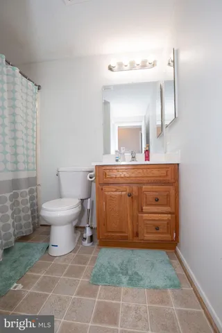 a bathroom with a toilet a sink and mirror