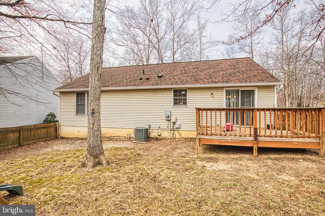 a backyard of a house with wooden deck and barbeque oven