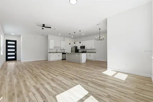 a kitchen with stainless steel appliances granite countertop a sink a stove and a wooden floor