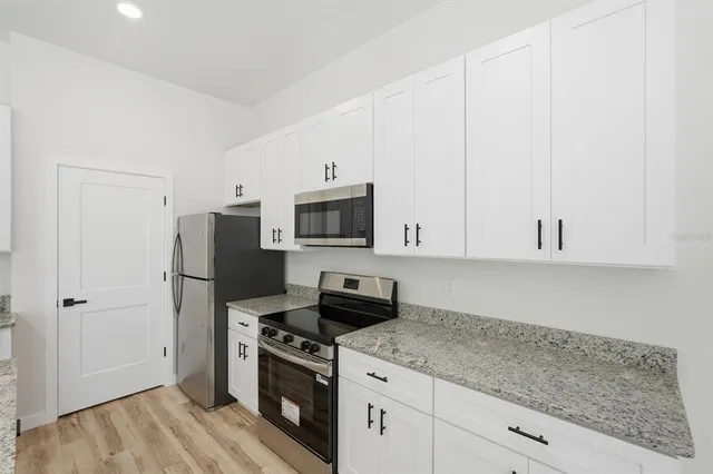 a kitchen with stainless steel appliances granite countertop a stove and a wooden cabinets