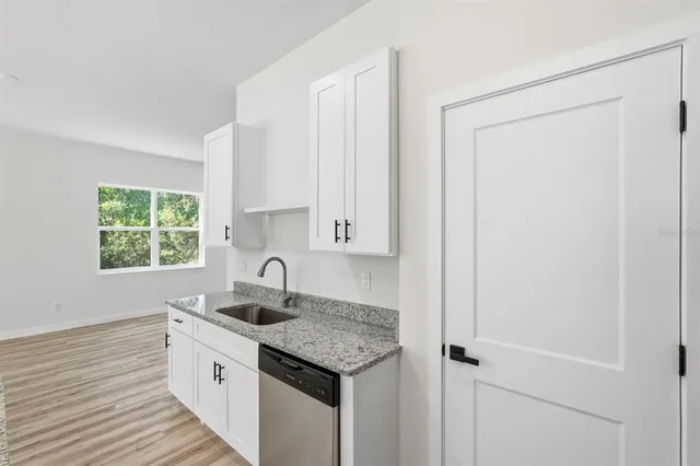 a large kitchen with stainless steel appliances a large counter top a stove a refrigerator and a sink