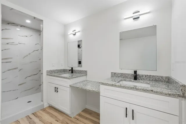 a bathroom with a granite countertop toilet a sink and a bathtub