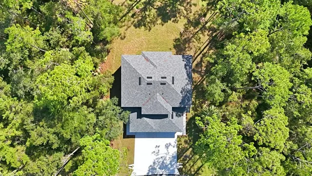 an aerial view of a house with a yard