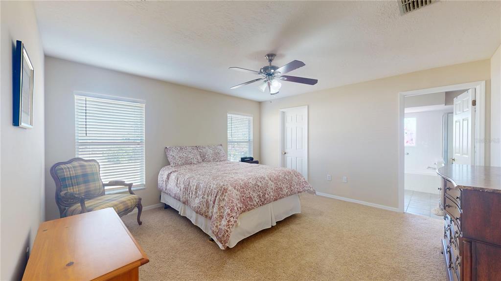 4427 North Bacall Loop Beverly Hills, FL 34465 - Photo 13 of 41 a spacious bedroom with a bed and a chandelier