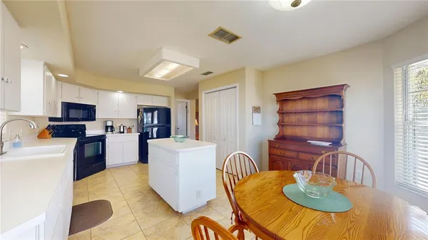 a large white kitchen with cabinets a sink and appliances