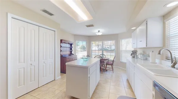 a kitchen with stainless steel appliances granite countertop a stove top oven a sink dishwasher a dining table and chairs with wooden floor