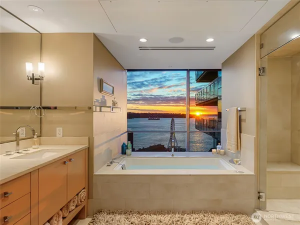 a bathroom with a tub sink shower and mirror