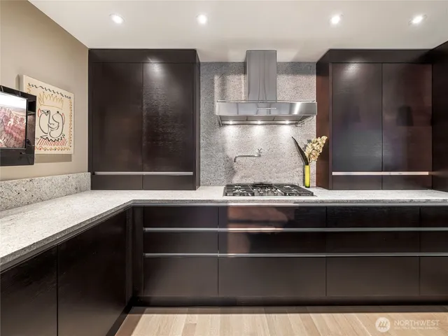 a view of kitchen with stainless steel appliances granite countertop a sink and wooden cabinets