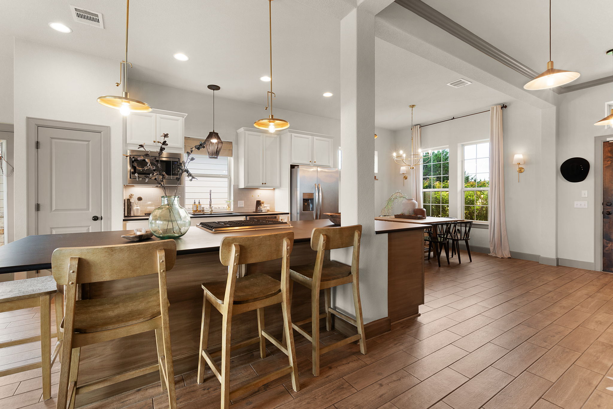155 Balcones Ridge Way Bertram, TX 78605 - Photo 15 of 37 A naturally illuminated open-concept kitchen and dining area features contemporary light fixtures.