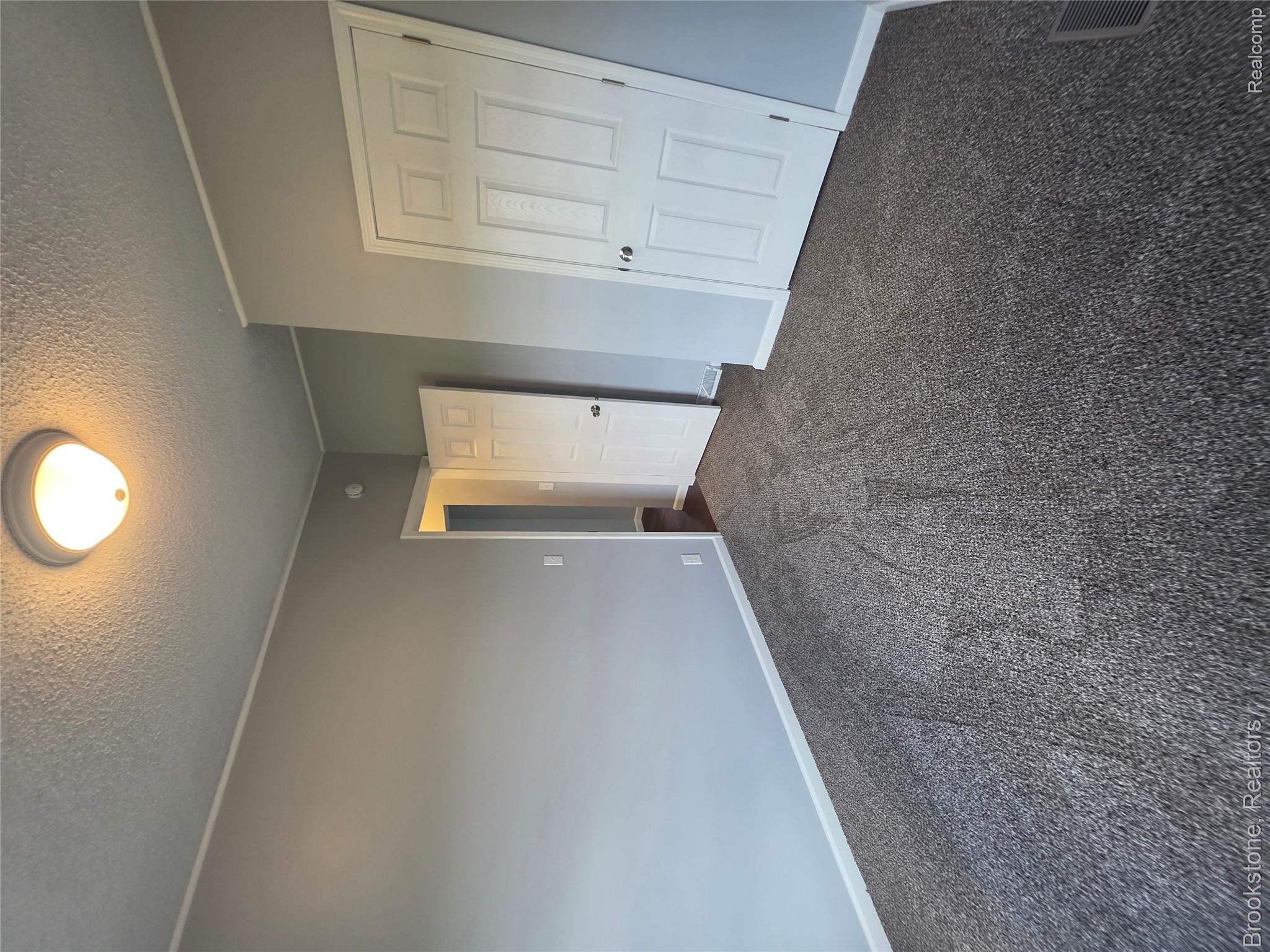 4064 East Wilson Road Clio, MI 48420 - Photo 20 of 23 Interior room with textured gray carpeting, light gray wall paint, and white trim