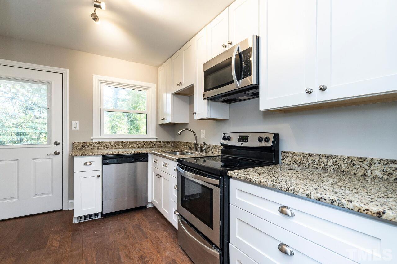 1105 Brighton Road Raleigh, NC 27610 - Photo 11 of 22 a kitchen with stainless steel appliances granite countertop a sink a stove a microwave and wooden cabinets