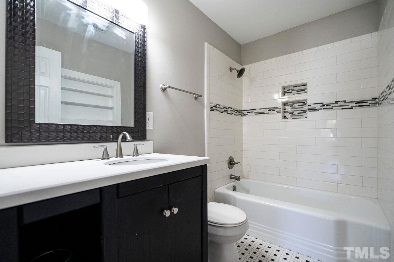 1105 Brighton Road Raleigh, NC 27610 - Photo 14 of 22 a bathroom with a bathtub shower sink vanity mirror and toilet