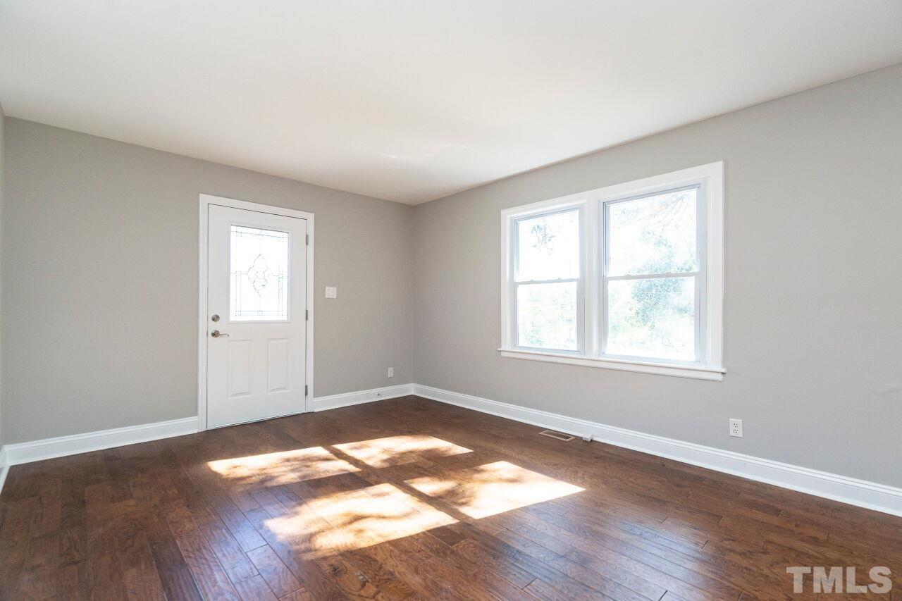 1105 Brighton Road Raleigh, NC 27610 - Photo 4 of 22 an empty room with wooden floor and windows