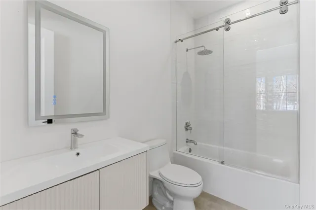 a bathroom with a bathtub shower sink vanity and toilet