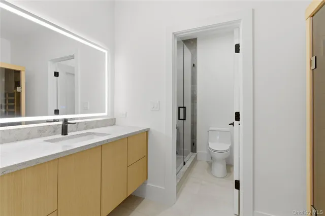 a bathroom with a sink a toilet and a mirror
