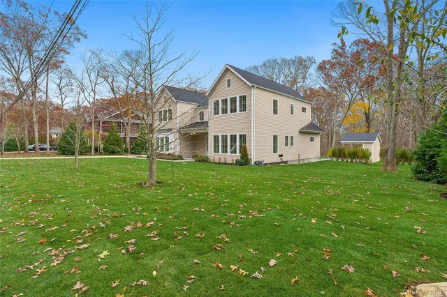 an aerial view of a house with swimming pool and large trees