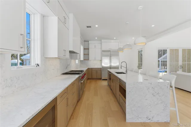 a large kitchen with stainless steel appliances granite countertop a lot of counter space and a sink