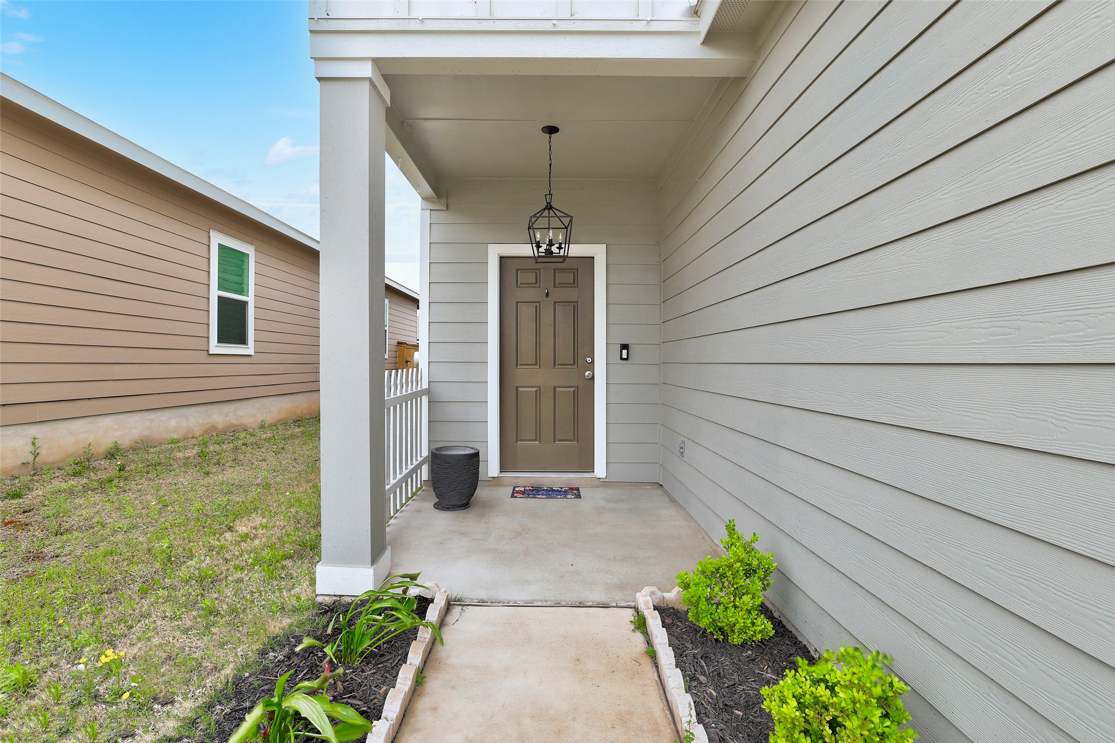 261 Night Riders Way Jarrell, TX 76537 - Photo 2 of 6 A welcoming front porch, shaded by a broad overhang, greets visitors with tasteful landscaping.