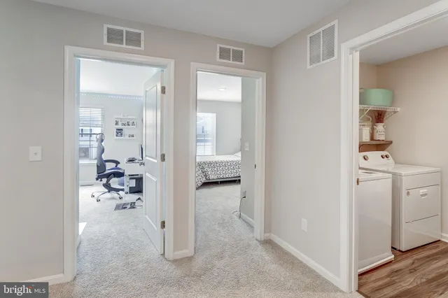 a view of a hallway with bathroom and wooden floor