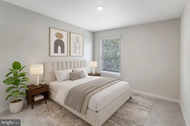 a bedroom with a bed table and a potted plant