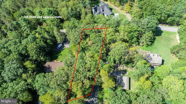 an aerial view of residential house with outdoor space and trees all around