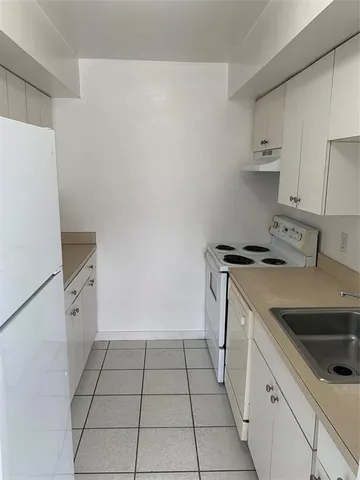 a kitchen with a sink a stove and cabinets
