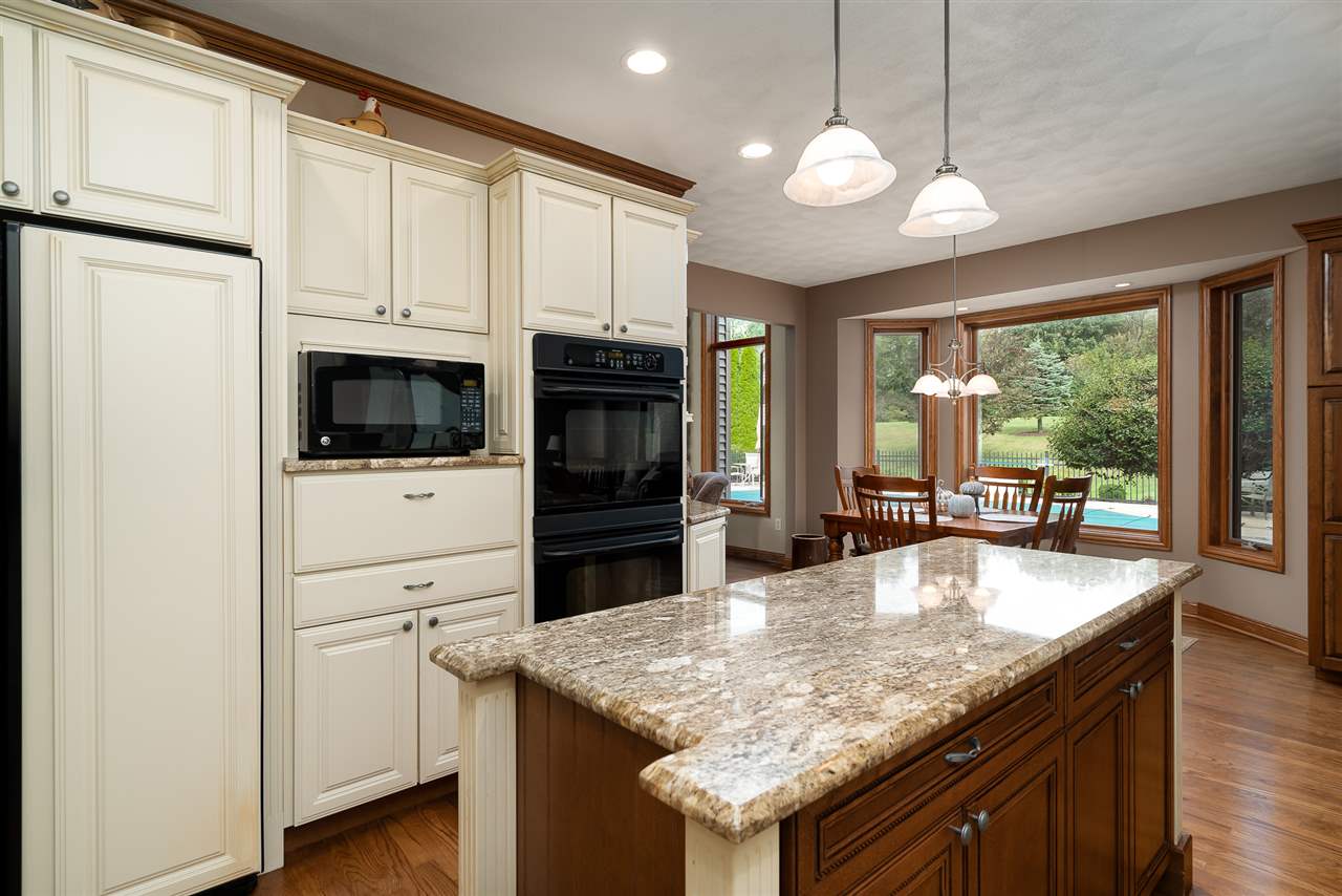 80 North Creek Road Roscoe, IL 61073 - Photo 11 of 25 a kitchen with granite countertop a center island and a stove top oven
