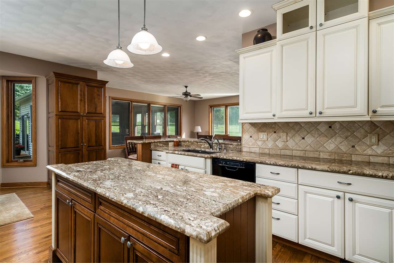 80 North Creek Road Roscoe, IL 61073 - Photo 12 of 25 a kitchen with granite countertop cabinets and chandelier