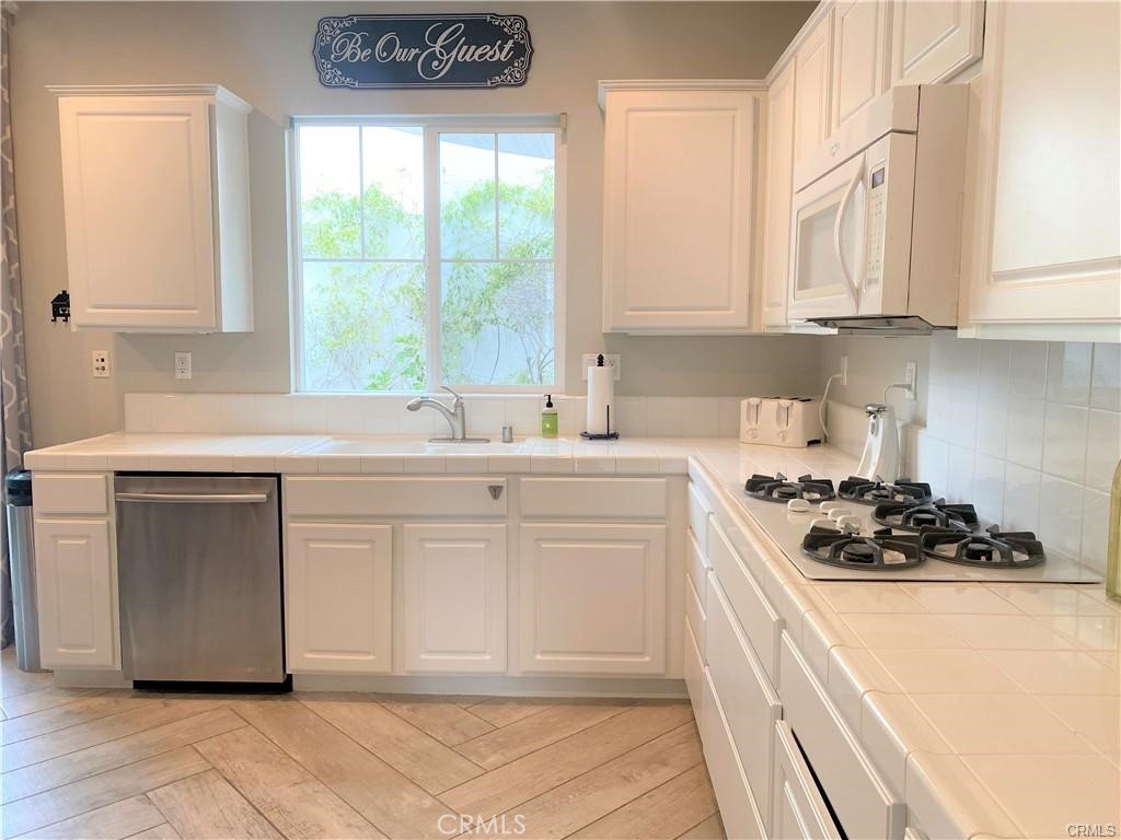 23 Bedstraw Loop Ladera Ranch, CA 92694 - Photo 5 of 37 a kitchen with white cabinets and white appliances
