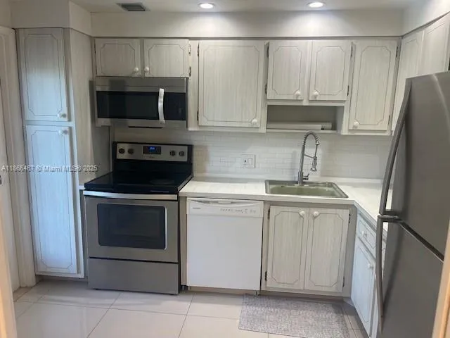 a kitchen with stainless steel appliances granite countertop a refrigerator stove and sink