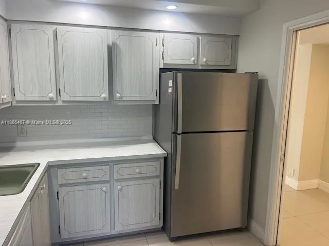 a kitchen with refrigerator and cabinets