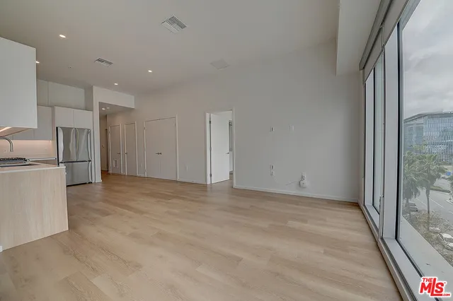 a view of empty room with a refrigerator