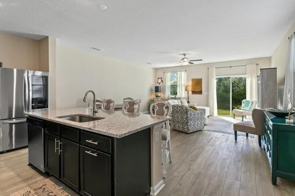 a kitchen with sink and view of living room