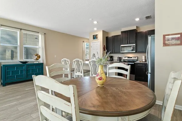 a kitchen with stainless steel appliances wooden floor dining table and chairs