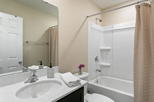 a bathroom with a granite countertop sink toilet and shower