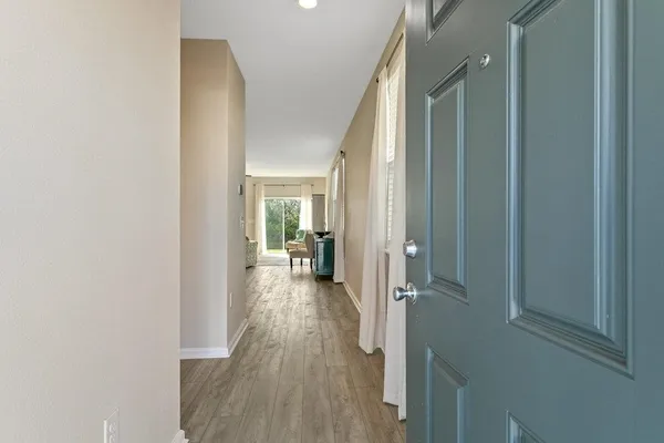 a view of a hallway with wooden floor and a living room