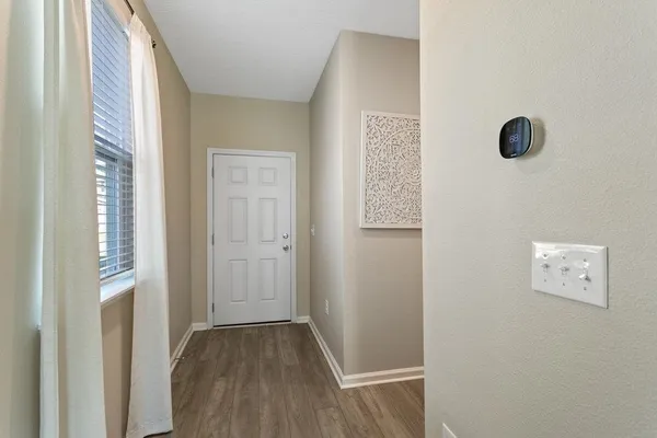 a view of a hallway with wooden floor and closet