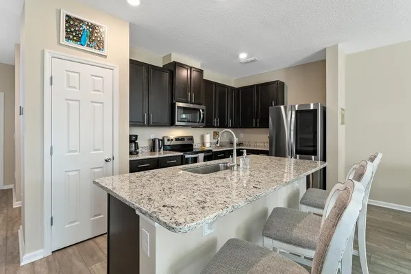 a kitchen with stainless steel appliances granite countertop a stove refrigerator and a refrigerator