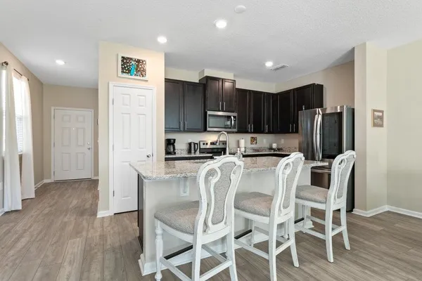 a kitchen with stainless steel appliances granite countertop a refrigerator and a stove top oven