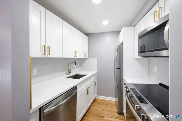 a kitchen with stainless steel appliances a sink stove and refrigerator