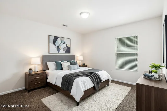 a bedroom with a bed two lamps with the walls