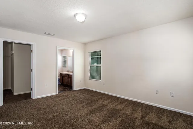 an empty room with closet and windows