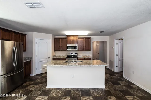 a large kitchen with a stove a refrigerator and a sink