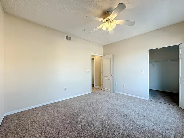 an empty room with a ceiling fan and a window