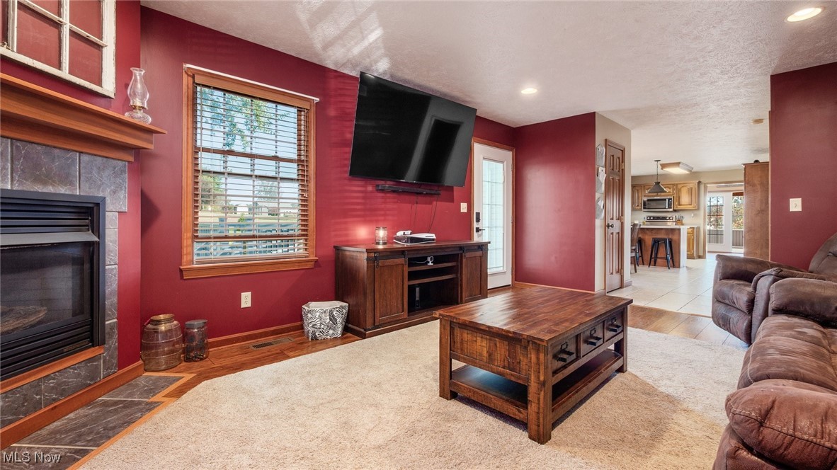 62960 James Road Cambridge, OH 43725 - Photo 14 of 40 Living area with a fireplace, plenty of natural light, light wood-type flooring, a textured ceiling, and recessed lighting