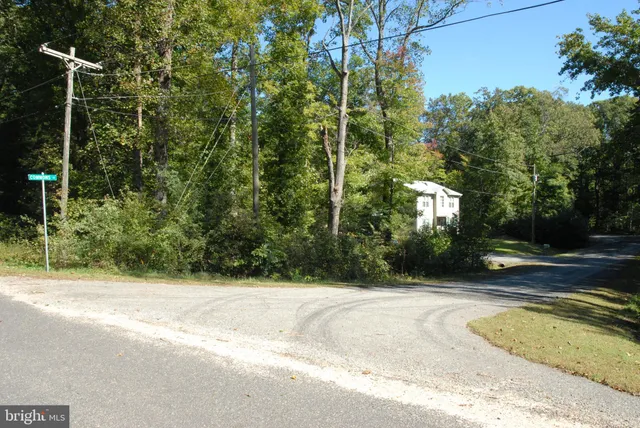 a view of a house with a backyard and trees