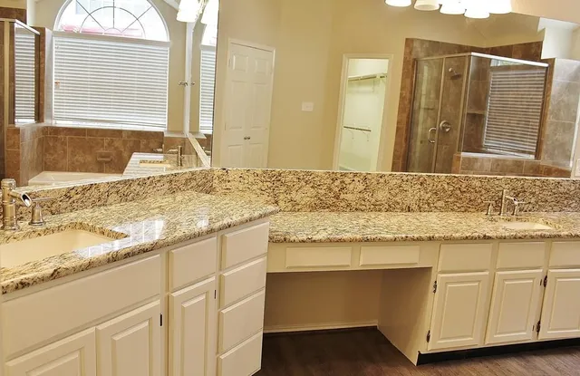 a bathroom with a granite countertop sink and a mirror